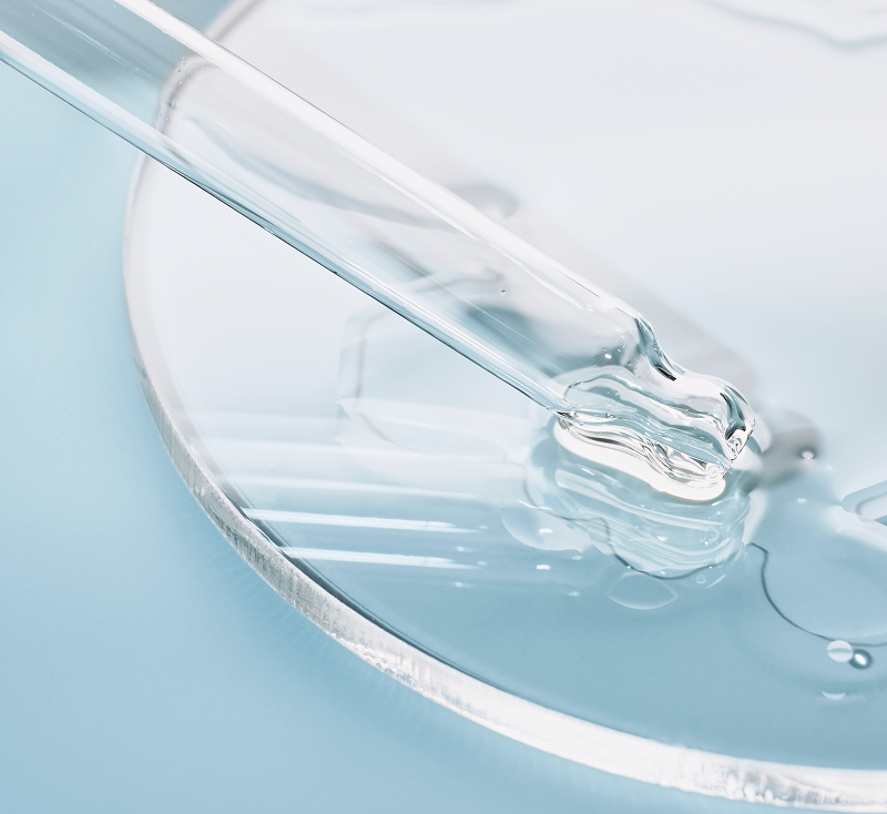 ピペットから液体を滴下している研究器具の写真