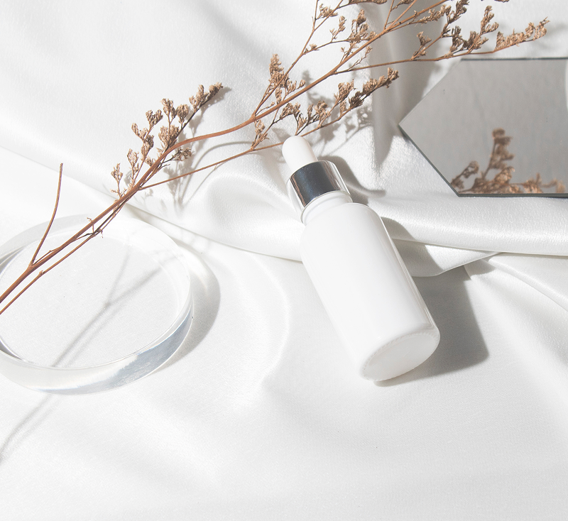 白い布の上に置かれたスキンケアボトルの写真